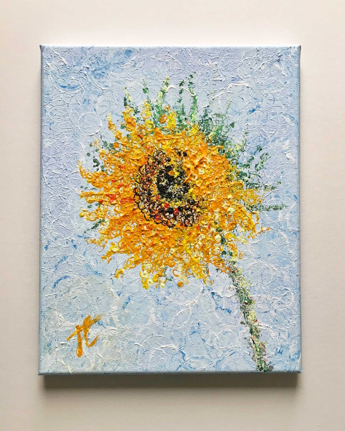 Acrylic painting on canvas of sunflower against a light blue background. The surface of the painting comprises layers of painted circles of different sizes to form the image.