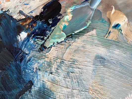 Artist trowel and palette with predominantly cool blue colours being mixed