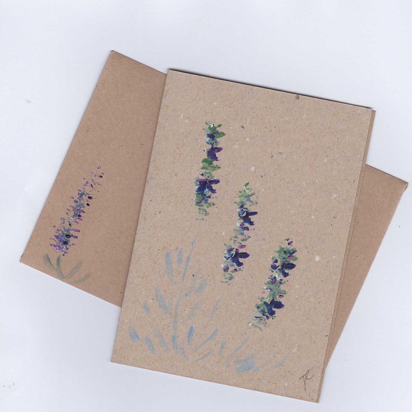 Brown paper card and envelope with floral designs shown on a white background
