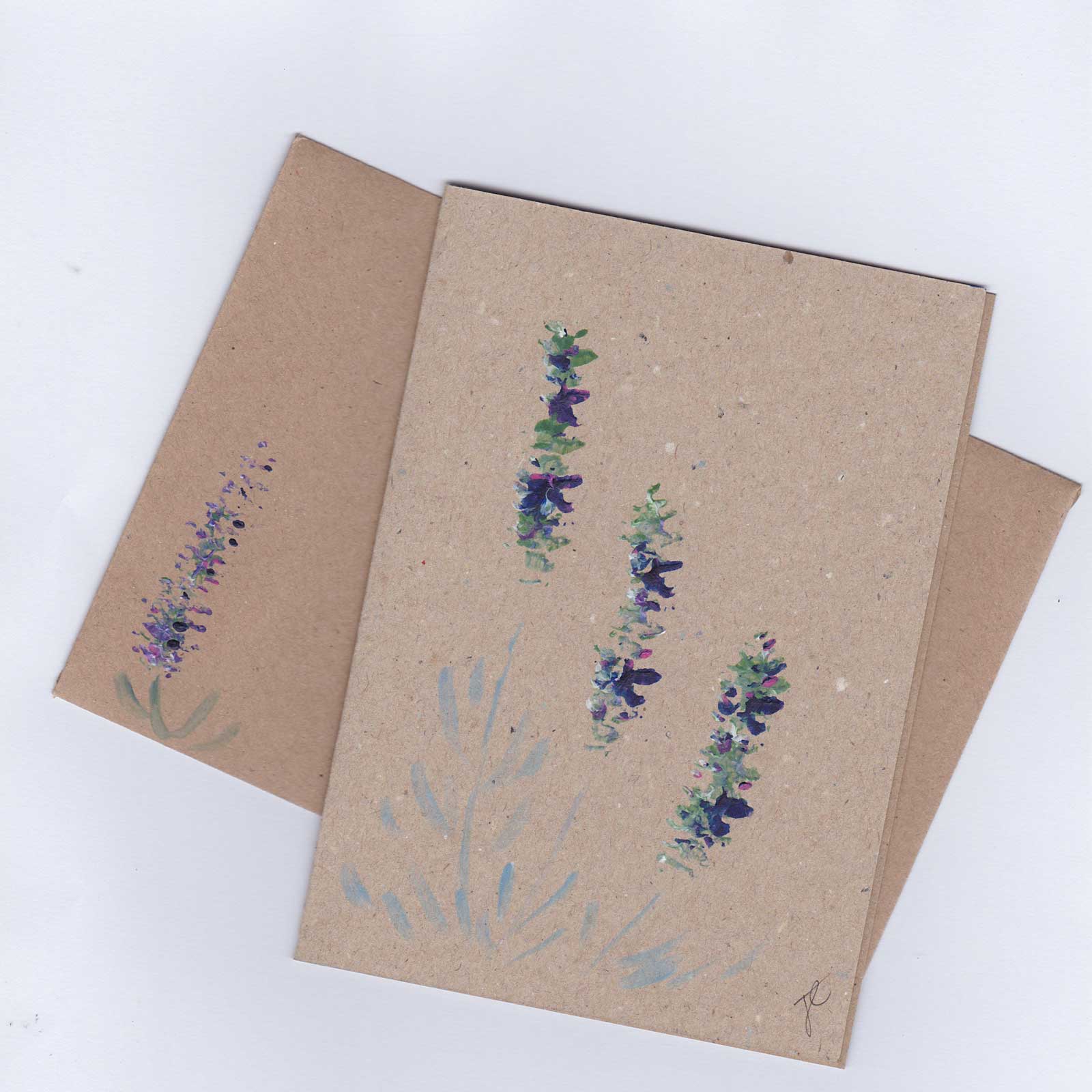 Brown paper card and envelope with floral designs shown on a white background