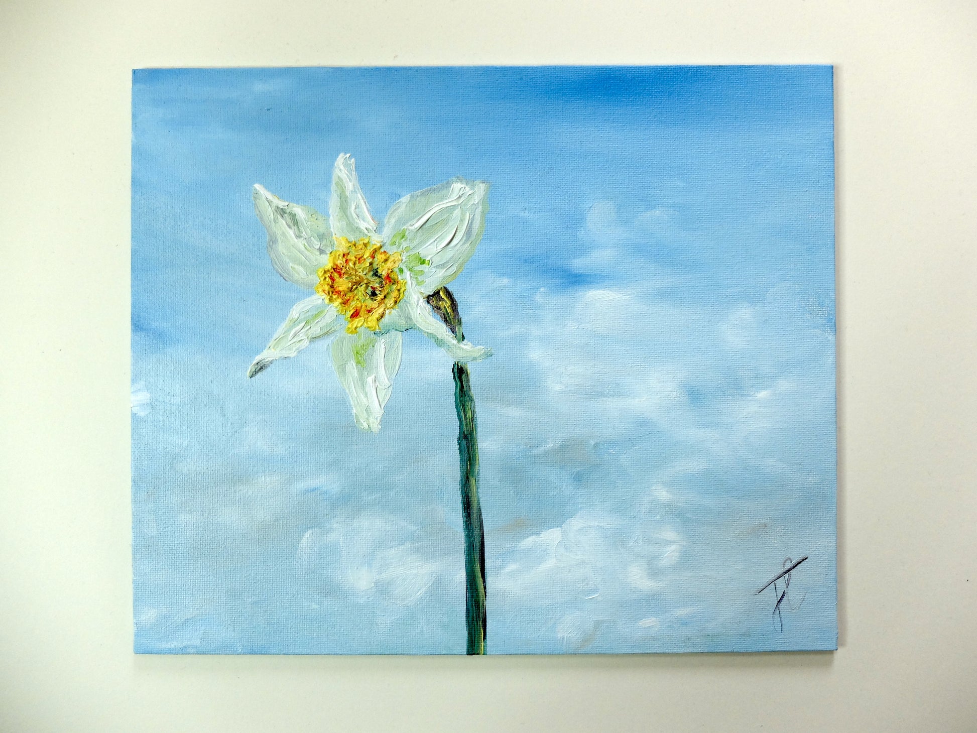 Painting of a single white daffodil with yellow centre, against a blue sky with soft white clouds. The paint comprising the daffodil's surface is textured. The painting is photographed against a light creamy-white background.